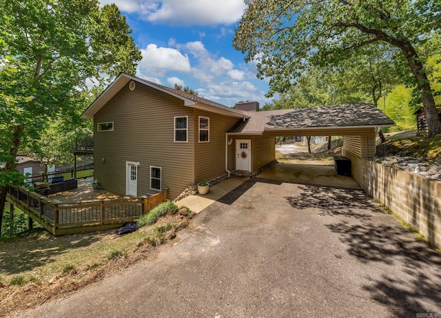 tri-level home featuring a carport and a wooden deck