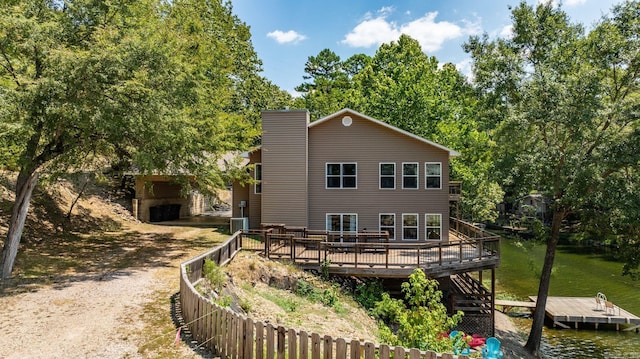 back of property with a deck and central AC