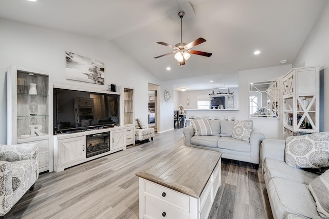 living room featuring ceiling fan, light hardwood / wood-style flooring, and lofted ceiling