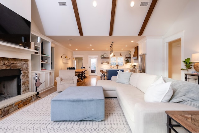 living room featuring a fireplace, light hardwood / wood-style floors, built in features, high vaulted ceiling, and beam ceiling