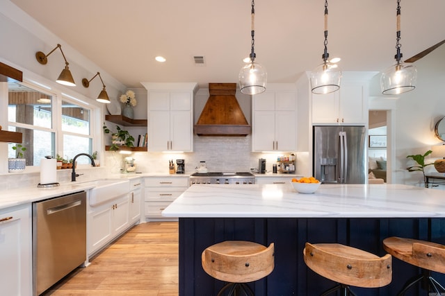 kitchen featuring white cabinets, stainless steel appliances, backsplash, and custom exhaust hood