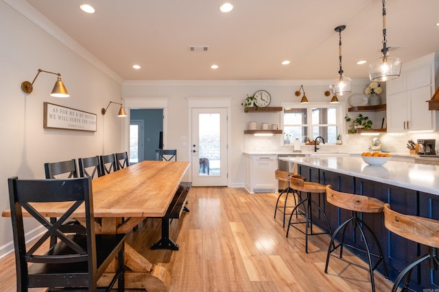 dining room featuring ornamental molding and light hardwood / wood-style flooring