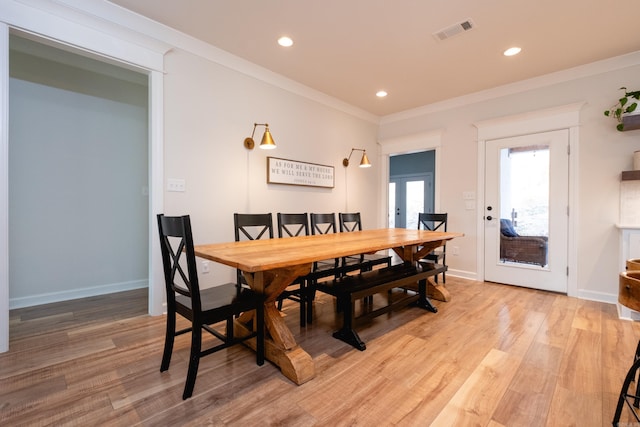 dining room with ornamental molding, french doors, and light wood-type flooring