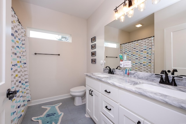 bathroom with vanity, a wealth of natural light, tile patterned floors, and toilet