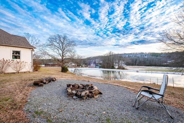 view of yard with a water view and an outdoor fire pit