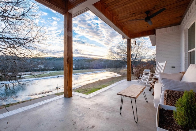 view of patio / terrace featuring ceiling fan and a water view