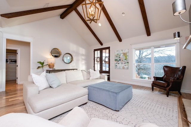 living room featuring high vaulted ceiling, a chandelier, beamed ceiling, and light hardwood / wood-style flooring