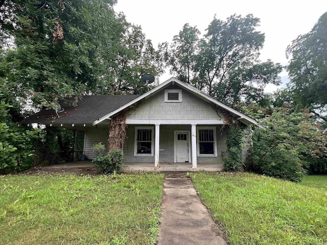 bungalow-style home with a front yard and covered porch