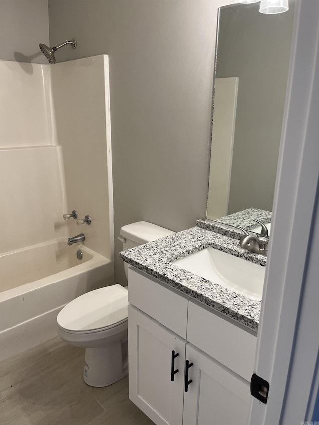 full bathroom featuring toilet, wood-type flooring, vanity, and bathtub / shower combination