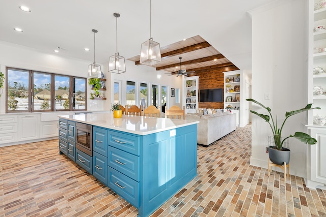 kitchen featuring stainless steel microwave, beam ceiling, white cabinetry, blue cabinets, and ceiling fan