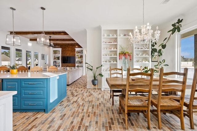 kitchen featuring decorative light fixtures, blue cabinets, beamed ceiling, and ceiling fan with notable chandelier