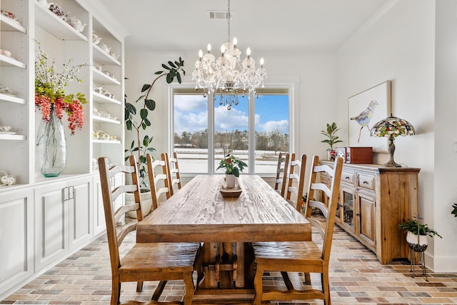 dining space with crown molding and a chandelier