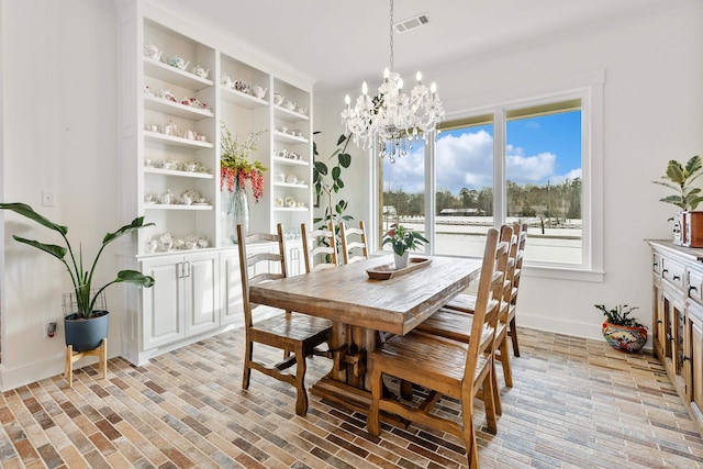 dining area with a chandelier and built in shelves