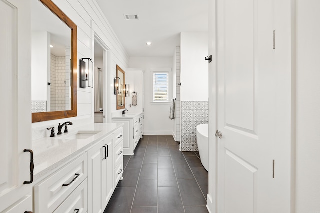 bathroom featuring vanity, tile patterned floors, and a bathing tub