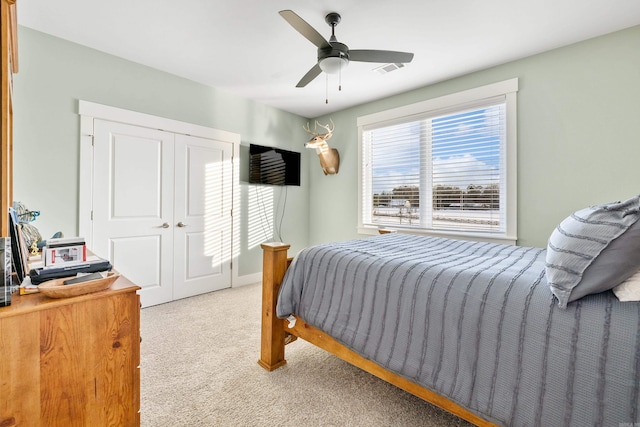 bedroom with ceiling fan, a closet, and light carpet