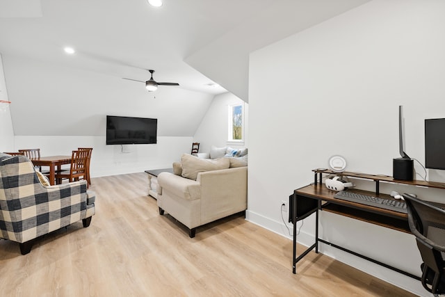 living room featuring ceiling fan, vaulted ceiling, and light hardwood / wood-style flooring