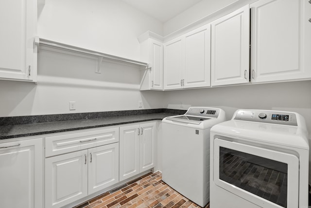 laundry room with washer and dryer and cabinets