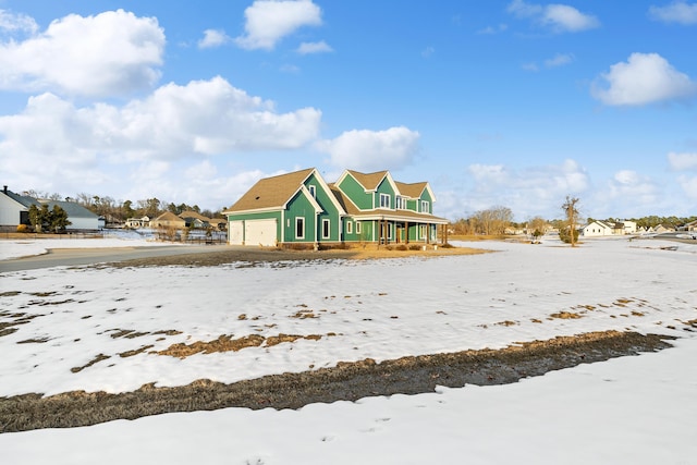 snow covered house featuring a garage