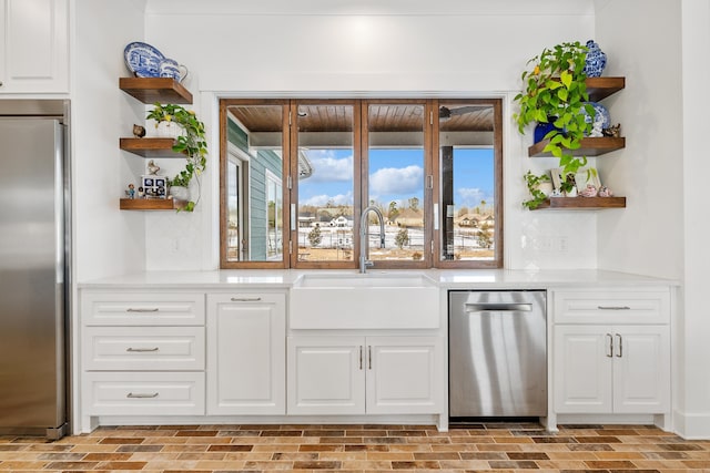 bar featuring appliances with stainless steel finishes, white cabinetry, and sink