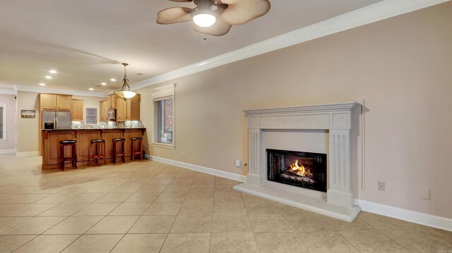 tiled living room with ceiling fan and crown molding