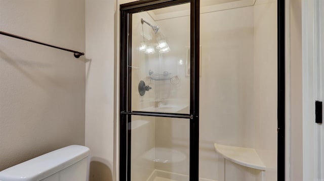 bathroom with toilet and a shower with door