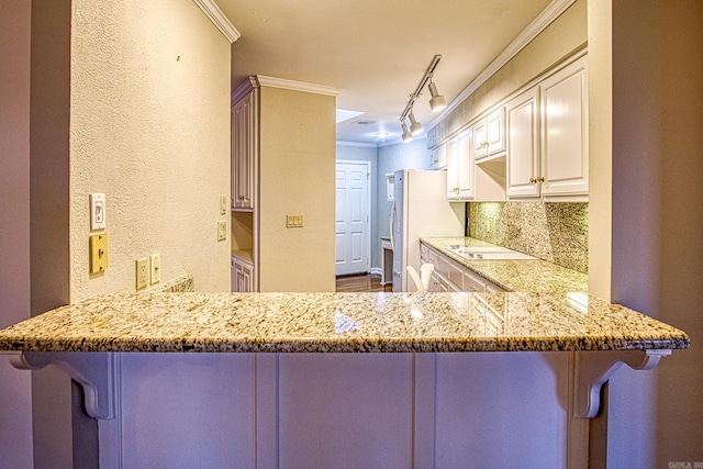 kitchen featuring kitchen peninsula, decorative backsplash, and a breakfast bar area