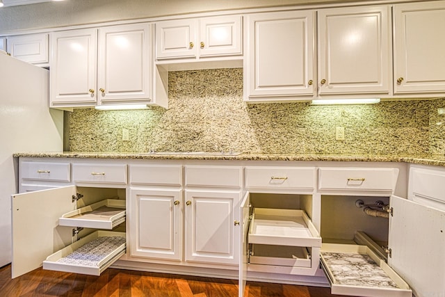 kitchen with dark hardwood / wood-style flooring, tasteful backsplash, white cabinets, and light stone countertops