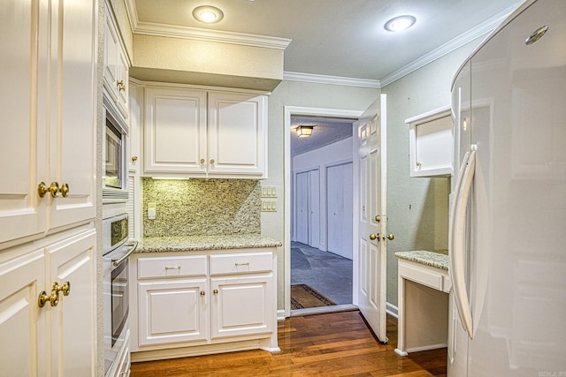 kitchen with crown molding, light stone countertops, dark hardwood / wood-style flooring, white cabinets, and fridge