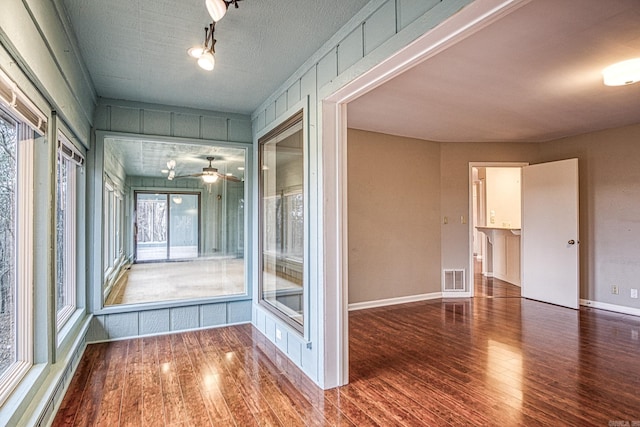 unfurnished sunroom with ceiling fan and plenty of natural light