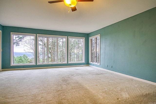 spare room featuring ceiling fan and carpet flooring