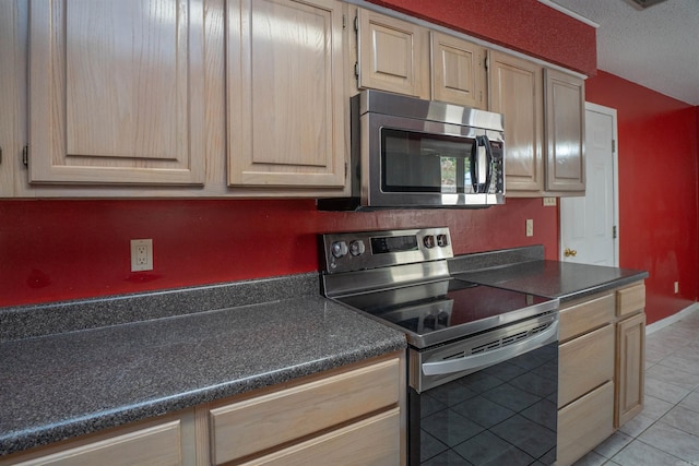 kitchen with light tile patterned floors, stainless steel appliances, and light brown cabinetry