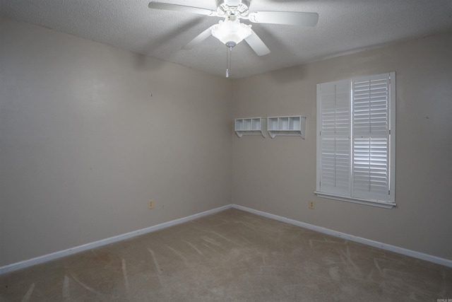 empty room with ceiling fan, a textured ceiling, and carpet flooring