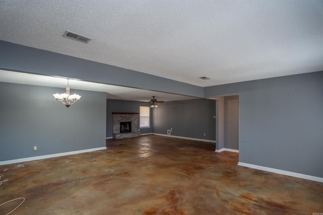 unfurnished living room featuring a textured ceiling, a brick fireplace, and ceiling fan with notable chandelier