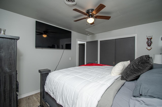 bedroom featuring hardwood / wood-style flooring, ceiling fan, and a closet