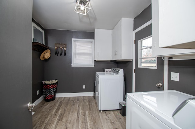 laundry room featuring separate washer and dryer, cabinets, and light wood-type flooring