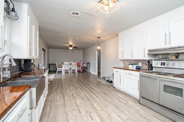 kitchen with backsplash, white cabinets, ceiling fan, and range with two ovens