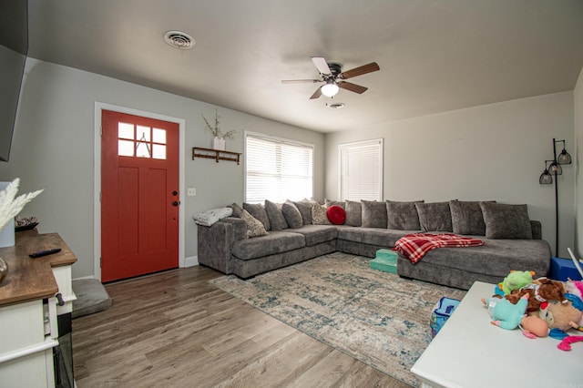 living room featuring hardwood / wood-style floors and ceiling fan