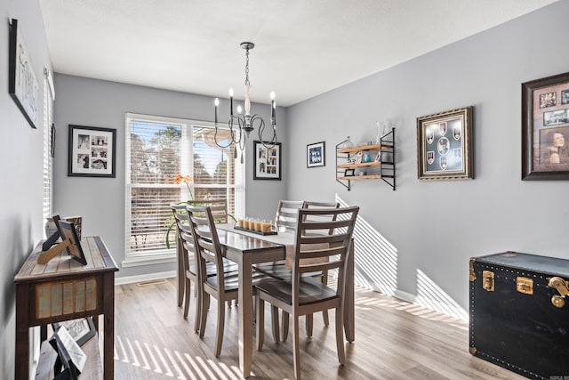 dining room featuring a notable chandelier and light wood-type flooring