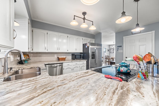 kitchen featuring hanging light fixtures, tasteful backsplash, white cabinetry, appliances with stainless steel finishes, and sink