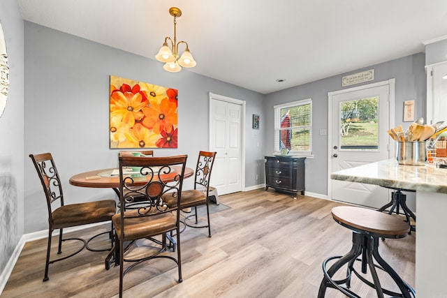 dining room with light hardwood / wood-style flooring and a chandelier