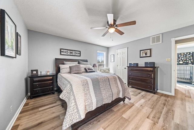 bedroom featuring a textured ceiling, ceiling fan, and light hardwood / wood-style floors