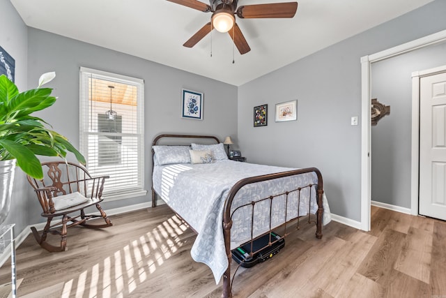 bedroom with multiple windows, ceiling fan, and light hardwood / wood-style flooring