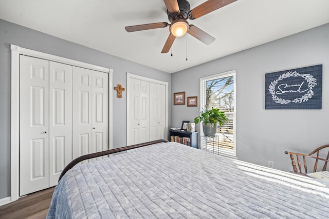 bedroom with two closets, ceiling fan, and wood-type flooring