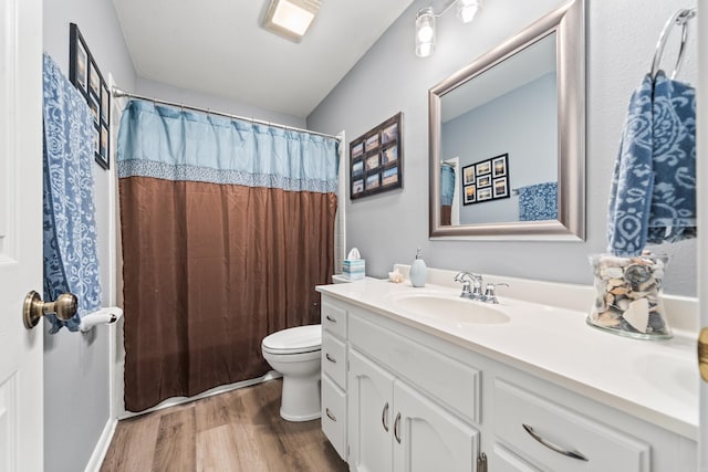 bathroom with a shower with shower curtain, toilet, vanity, and wood-type flooring