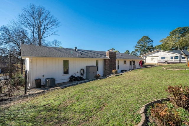 rear view of house with a yard and central AC unit