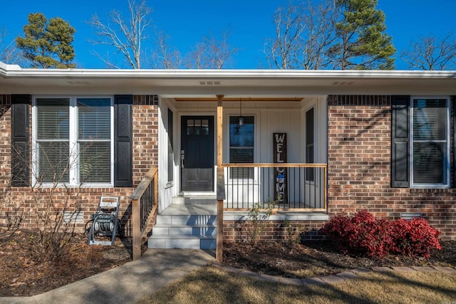 view of exterior entry featuring covered porch