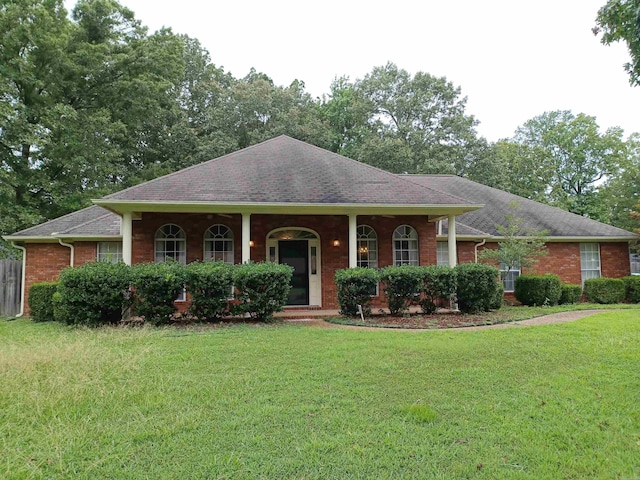 ranch-style home featuring covered porch and a front lawn