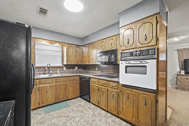 kitchen featuring a textured ceiling, black appliances, and sink