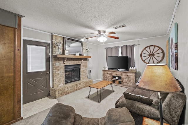 carpeted living room featuring a brick fireplace, a textured ceiling, ceiling fan, and ornamental molding