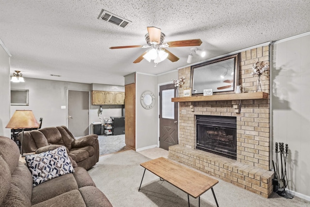 living room with a textured ceiling, light colored carpet, a brick fireplace, and ceiling fan